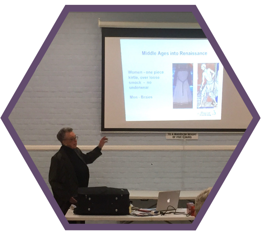 A picture of a Liza Jones demonstrating on a slide show types of underwear through the ages